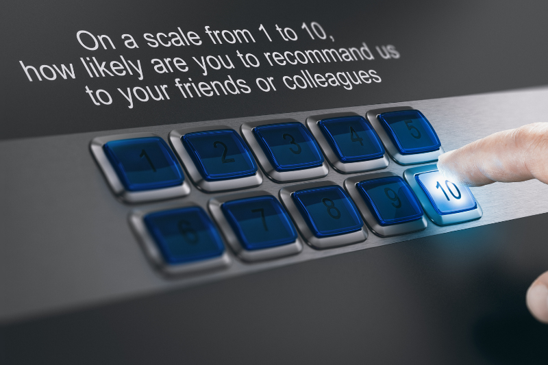 A hand presses the 10 button on a keypad below a survey question asking, On a scale from 1 to 10, how likely are you to recommend us to your friends or colleagues?.