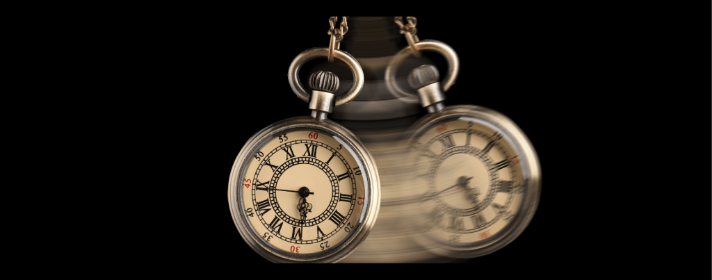 A gold pocket watch hanging from a chain, shown in motion with a blur effect.